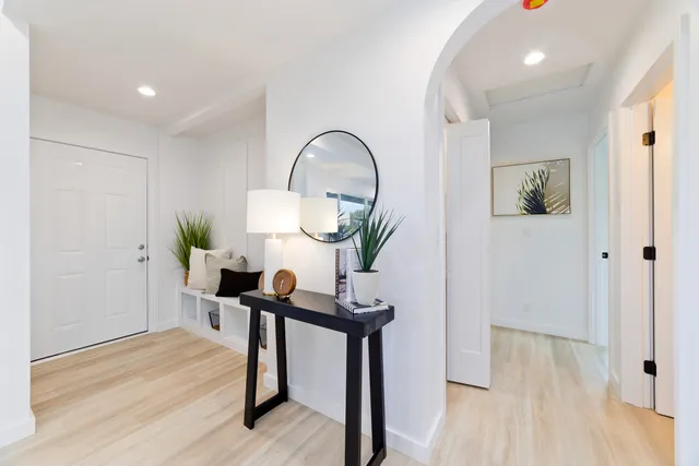 a view of a hallway with wooden floor and furniture