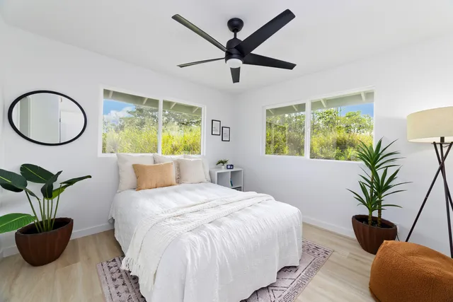 a bedroom with a large bed and a potted plant