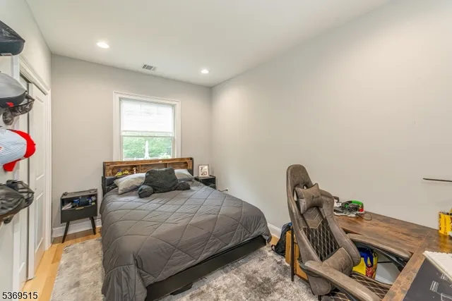 a bedroom with a bed and a wooden floor
