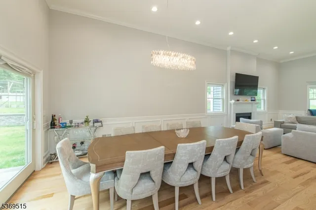 a view of a dining room with furniture a fireplace and wooden floor