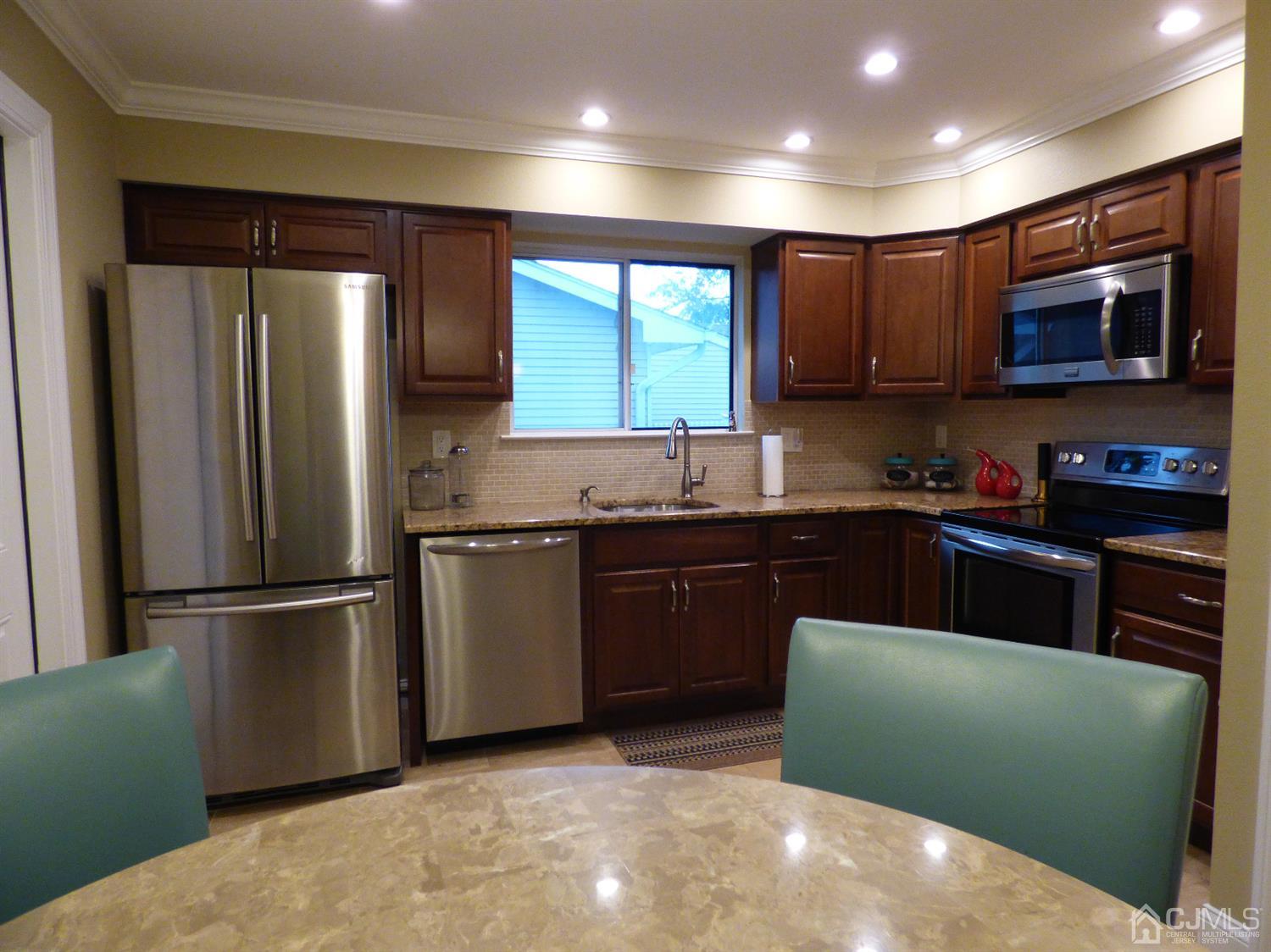 797B Sparta Road, Unit 797A Monroe Township, NJ 08831 - Photo 13 of 25 a kitchen with stainless steel appliances granite countertop a refrigerator a sink dishwasher a refrigerator with wooden cabinets and a refrigerator