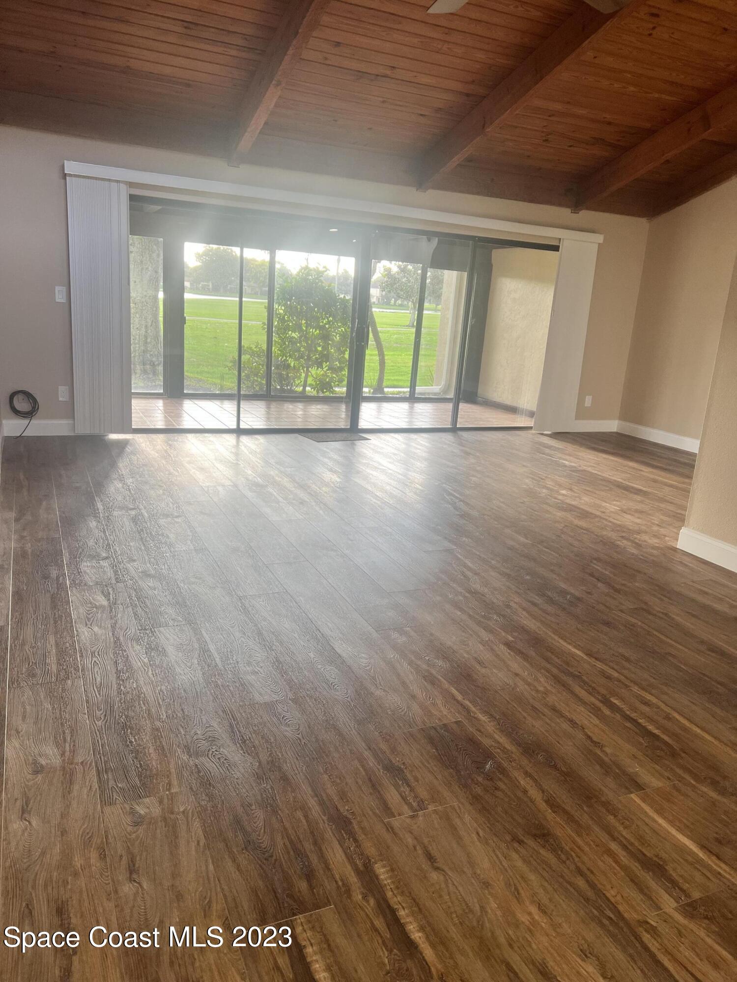 161 Augusta Way Melbourne, FL 32940 - Photo 7 of 26 an empty room with wooden floor and windows