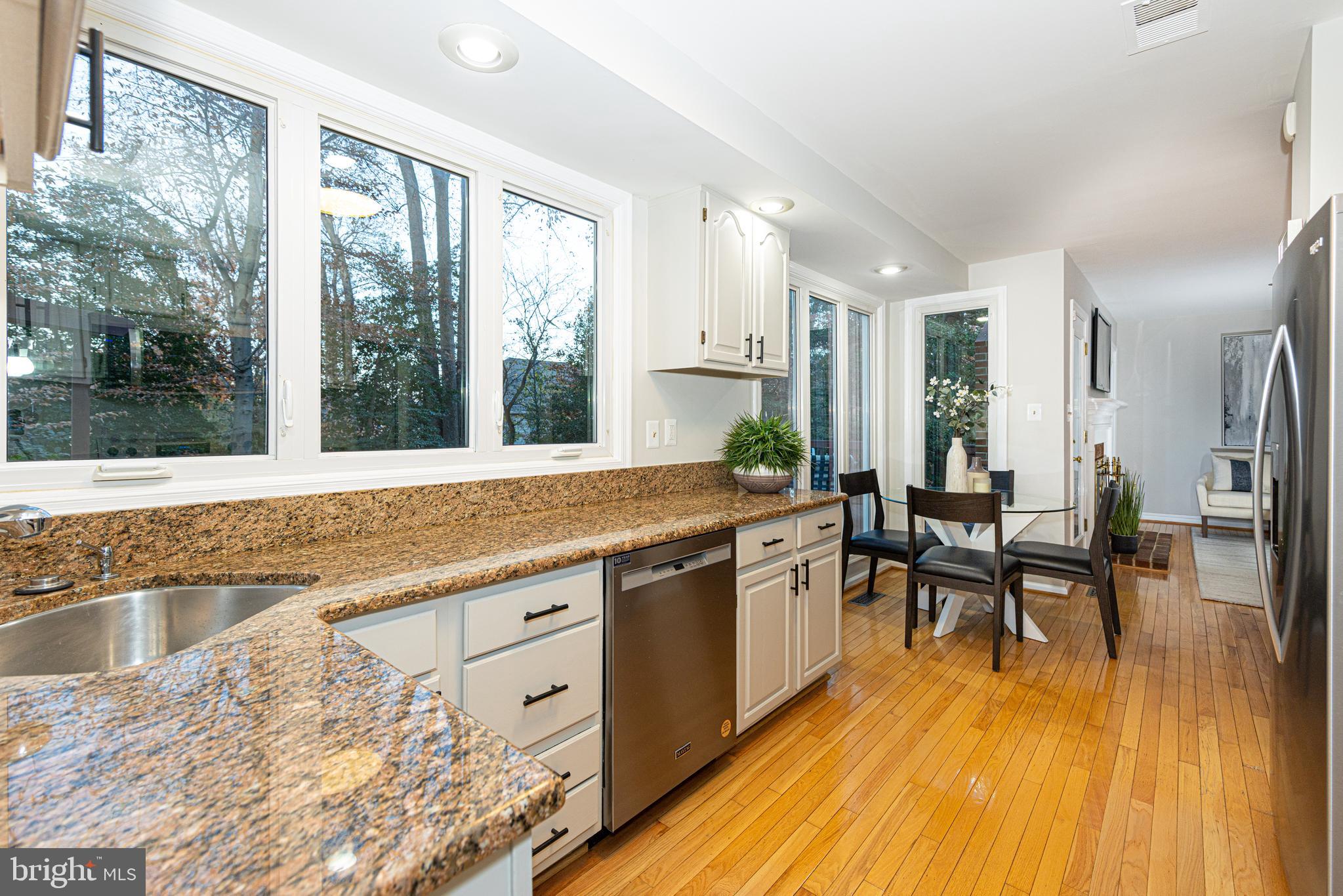 9596 Oakington Drive Fairfax Station, VA 22039 - Photo 15 of 52 a large white kitchen with wooden floor and glass windows