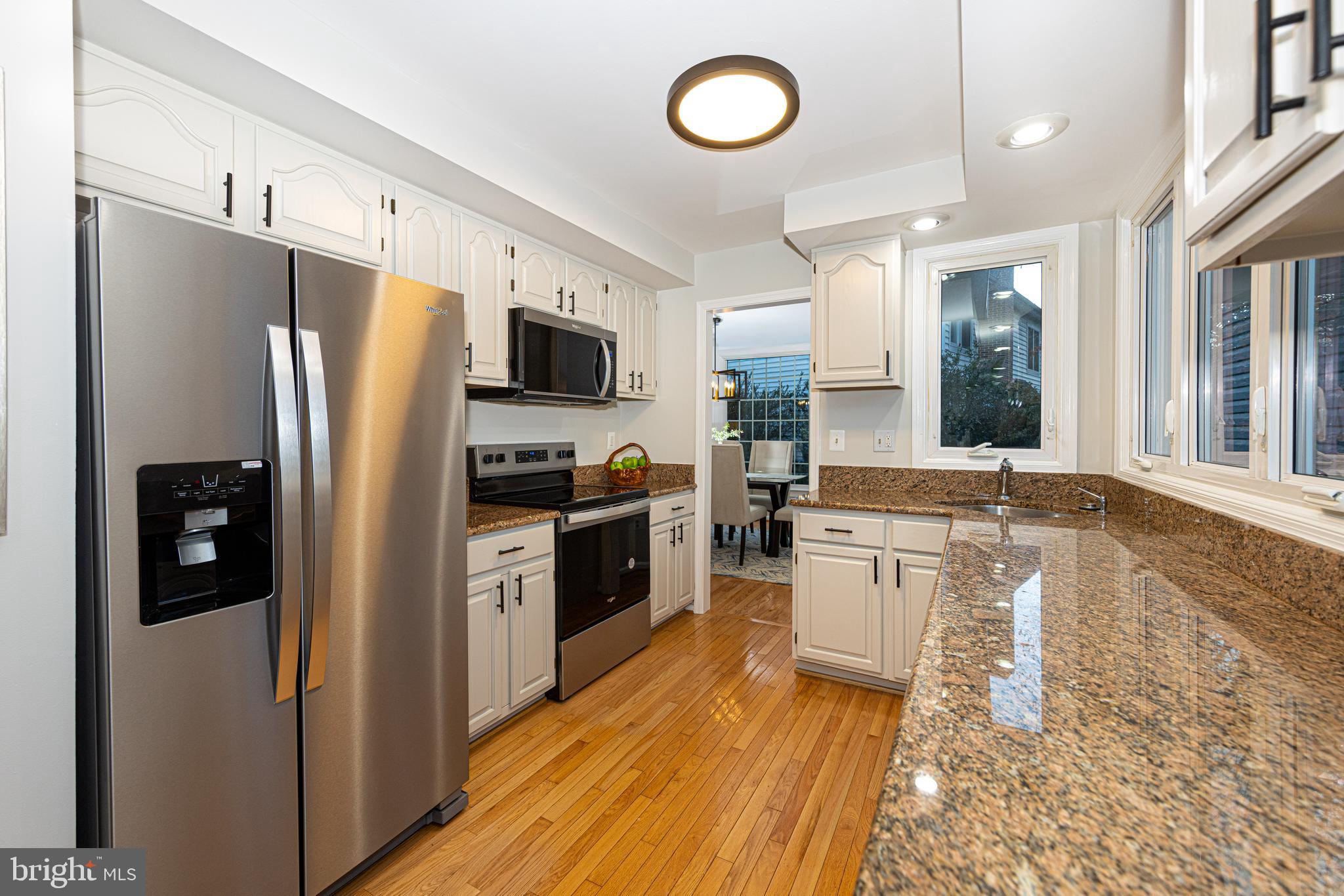9596 Oakington Drive Fairfax Station, VA 22039 - Photo 18 of 52 a kitchen with a refrigerator cabinets and wooden floor