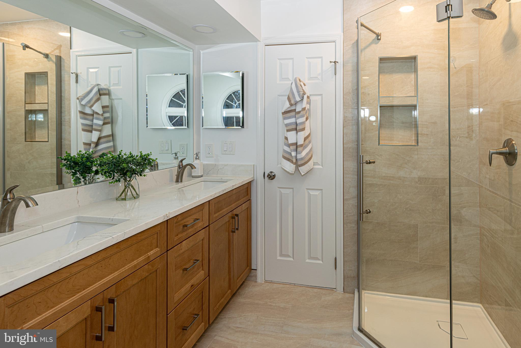 9596 Oakington Drive Fairfax Station, VA 22039 - Photo 24 of 52 a spacious bathroom with a shower sink and mirror