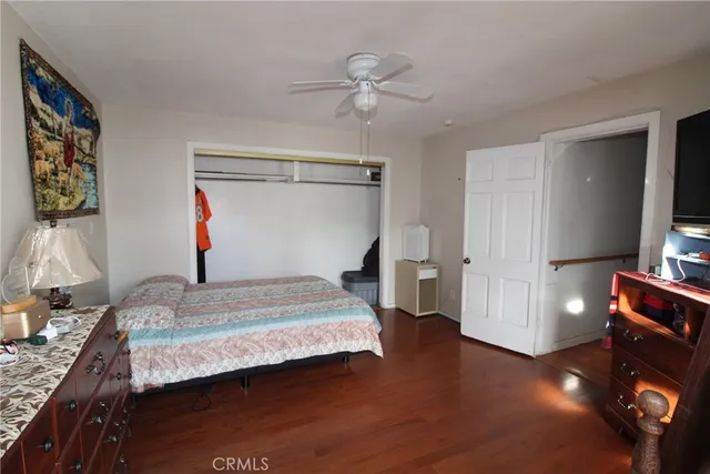 a bedroom with a bed and a flat tv screen on the dresser