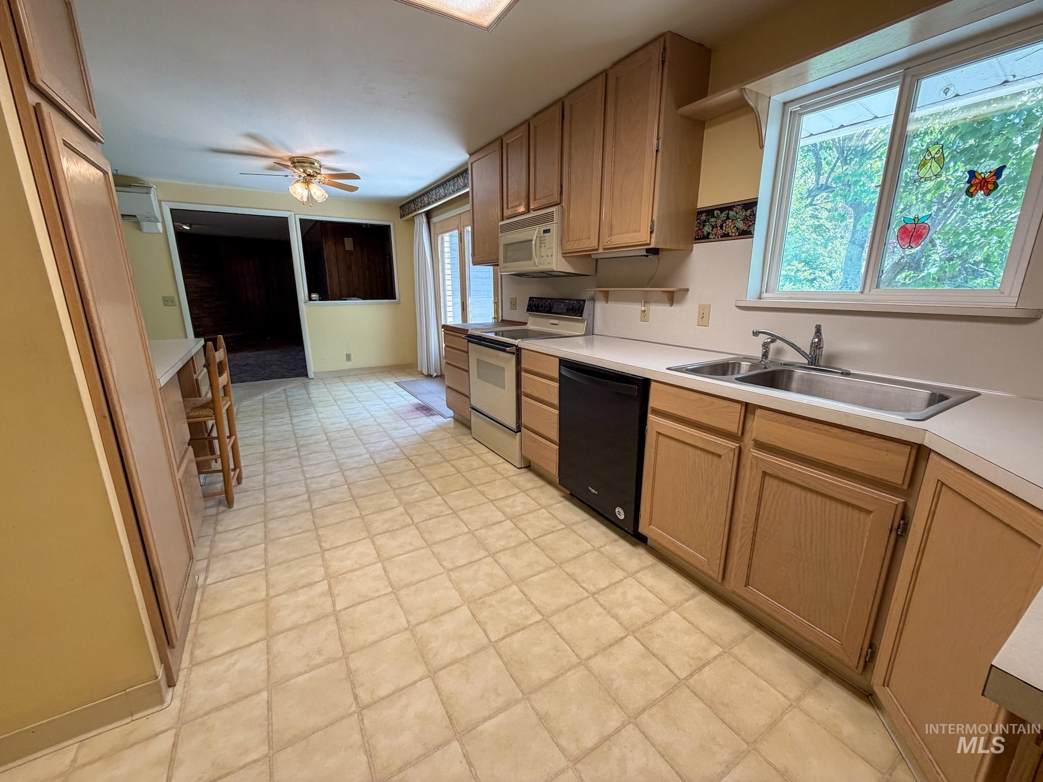 1924 H Street Rupert, ID 83350 - Photo 9 of 13 Kitchen featuring extensive light wood cabinetry, white countertops, tile flooring, and a double basin stainless steel sink