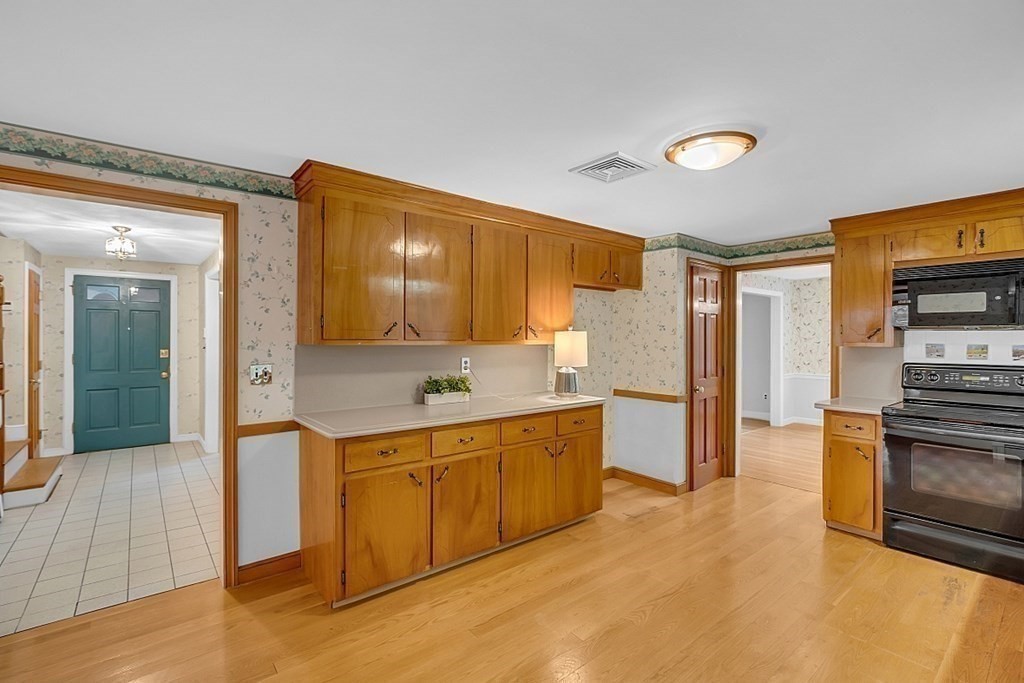 56 Brook Trail Road Concord, MA 01742 - Photo 8 of 25 a large kitchen with a sink and dishwasher a stove top oven with wooden floor