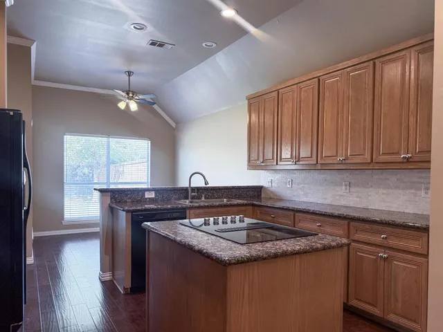 a kitchen with a sink a stove cabinets and wooden floor
