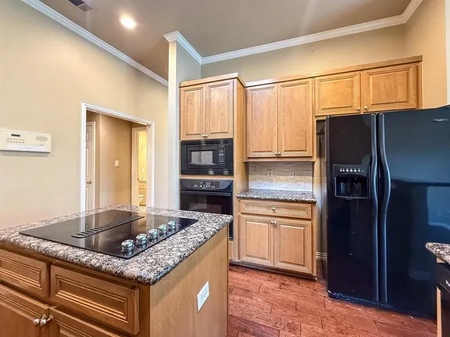 a kitchen with stainless steel appliances granite countertop a refrigerator and a sink