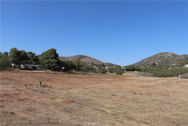 a view of dirt field with mountain in background