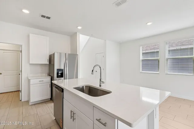 a kitchen with stainless steel appliances granite countertop a sink a refrigerator and a stove