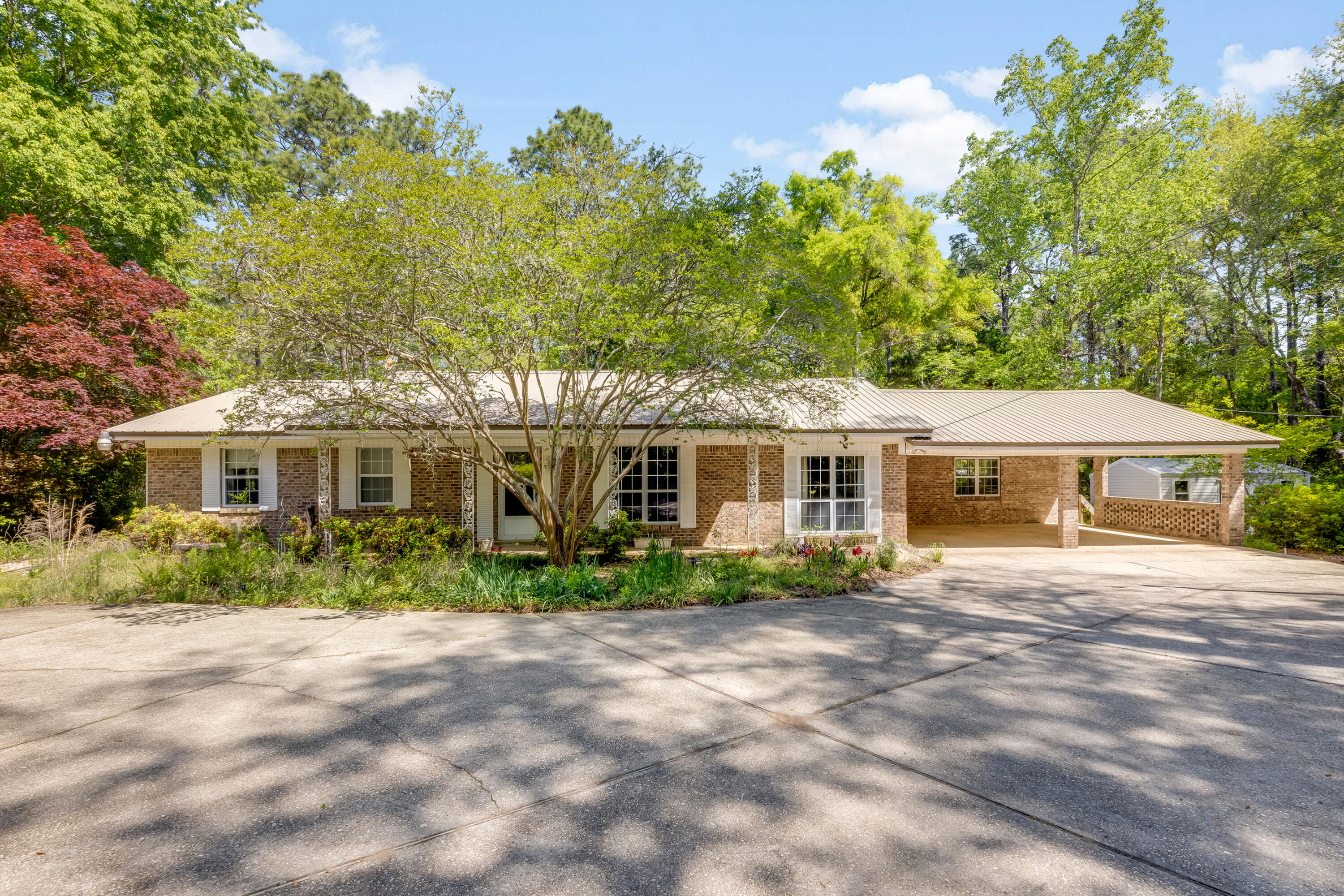 3607 Poverty Creek Road Crestview, FL 32539 - Photo 1 of 42 a front view of a house with a garden