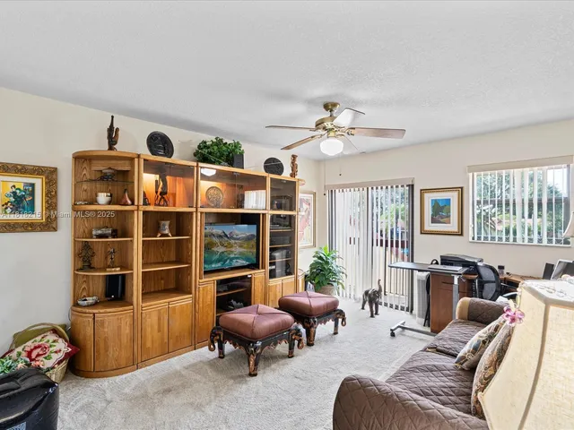 a living room with furniture a flat screen tv and windows