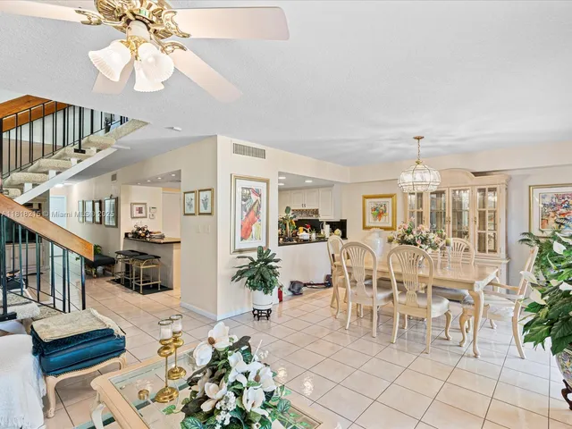 a living room with furniture a dining table and a chandelier
