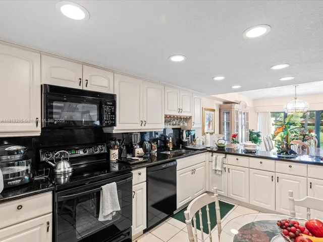a kitchen with a sink stainless steel appliances and white cabinets
