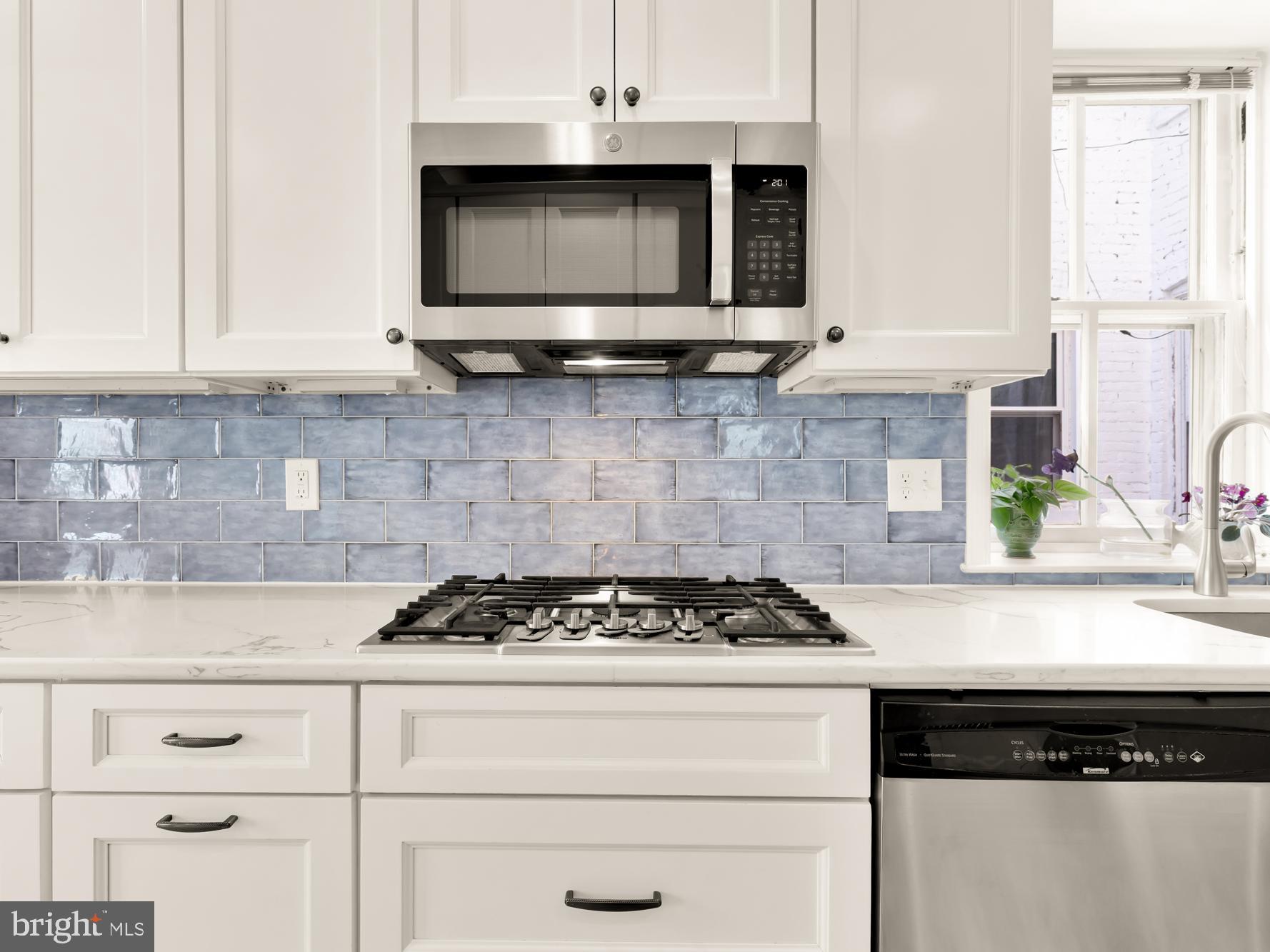 1716 Euclid Street Northwest Washington, DC 20009 - Photo 16 of 54 a kitchen with stainless steel appliances granite countertop white cabinets stove top oven and sink