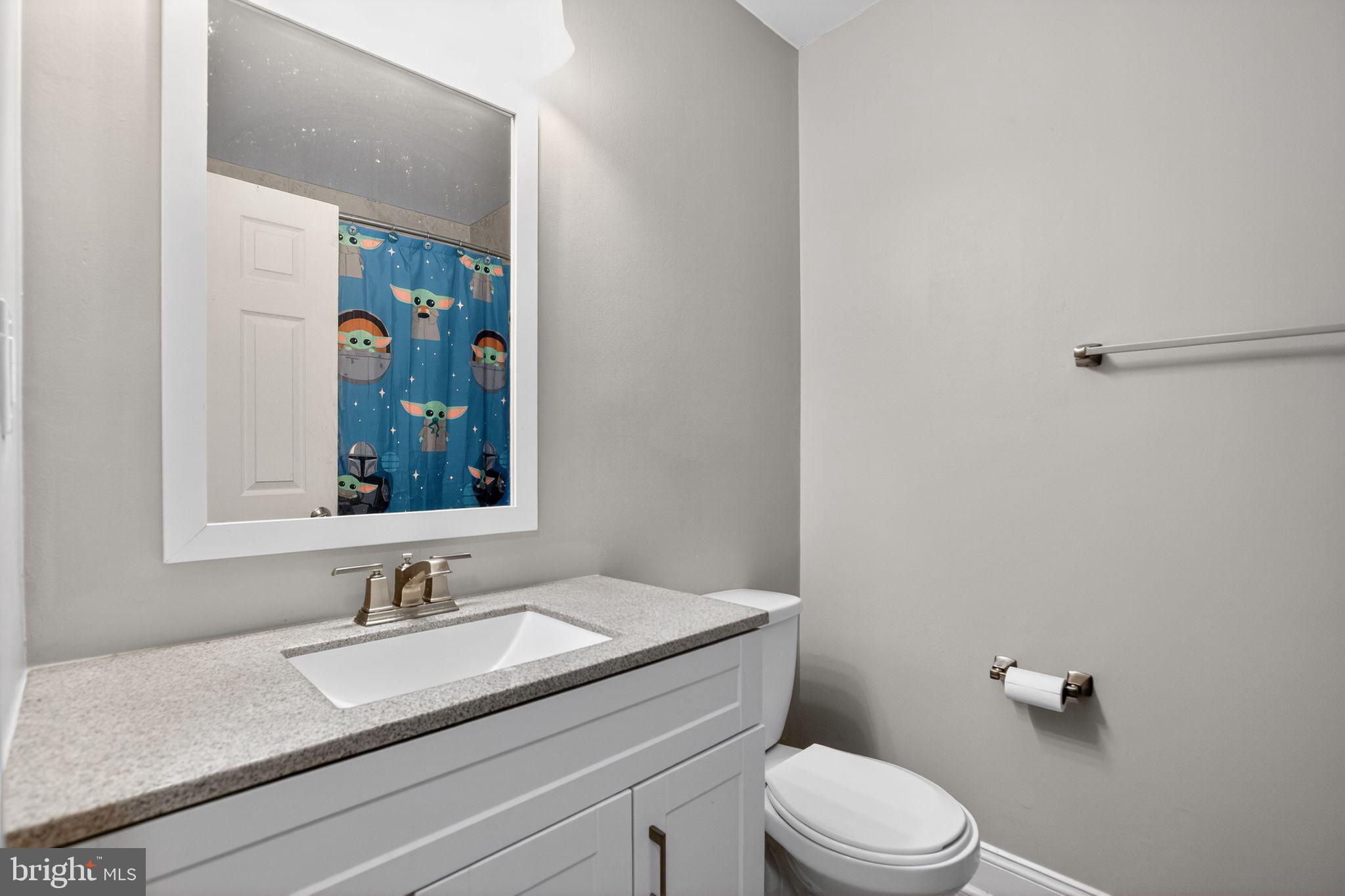 11789 Little Cove Point Road Lusby, MD 20657 - Photo 16 of 16 a bathroom with a granite countertop sink toilet and mirror