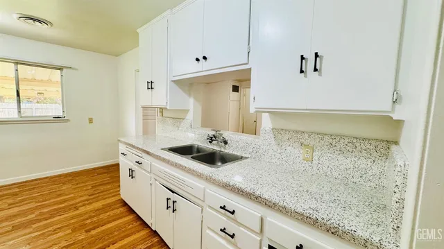 a bathroom with a granite countertop sink and a shower