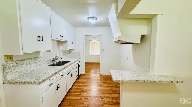 a large kitchen with granite countertop a sink and a stove