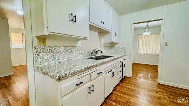 a bathroom with granite countertop double vanity and a shower