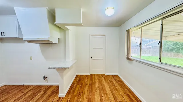 a view of a bedroom with wooden floor and a window