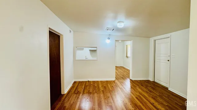 a view of empty room with wooden floor