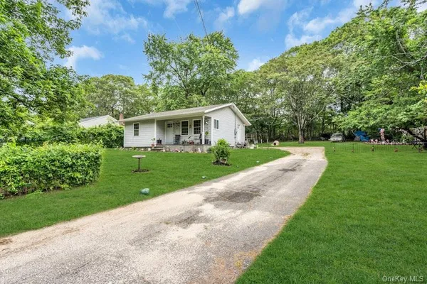 a front view of a house with yard and green space