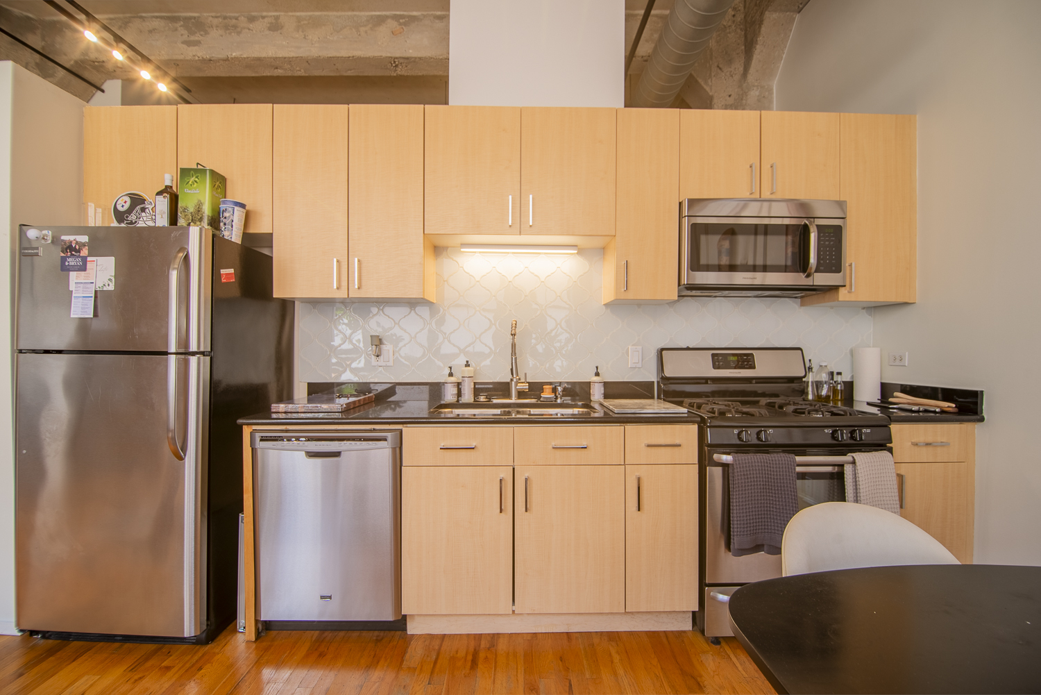 817 West Washington Boulevard, Unit 102 Chicago, IL 60607 - Photo 5 of 10 a kitchen with stainless steel appliances granite countertop a stove a sink and a refrigerator