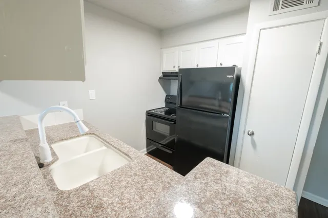 a kitchen with a refrigerator and a sink
