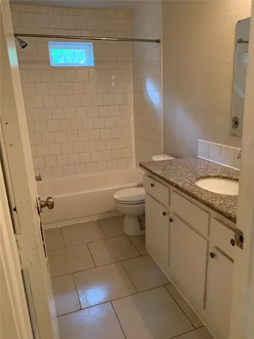 a bathroom with a granite countertop sink a toilet and shower