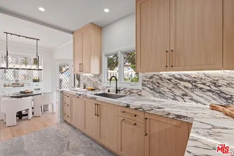 a bathroom with a granite countertop sink a mirror and a bathtub