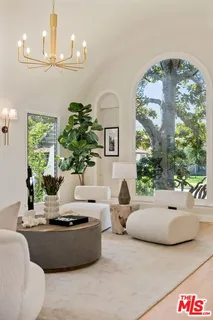 a living room with furniture a chandelier and a fireplace