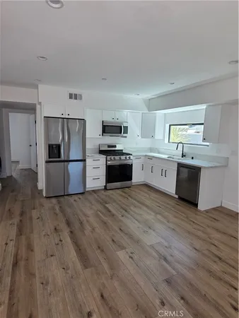 a large kitchen with cabinets and stainless steel appliances