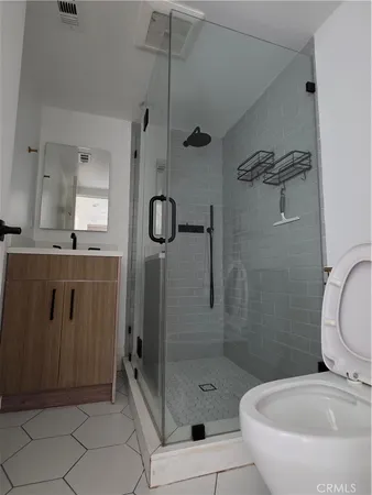 a bathroom with a shower a mirror and a sink