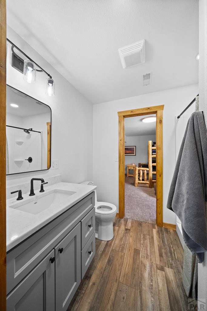 965 Newton Road Pueblo, CO 81005 - Photo 25 of 47 a en suite bathroom with a granite countertop sink toilet and a mirror