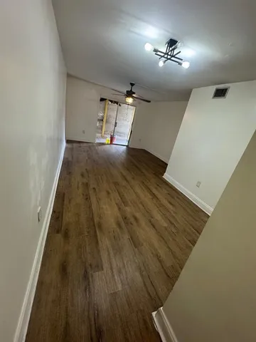 a view of empty room with wooden floor