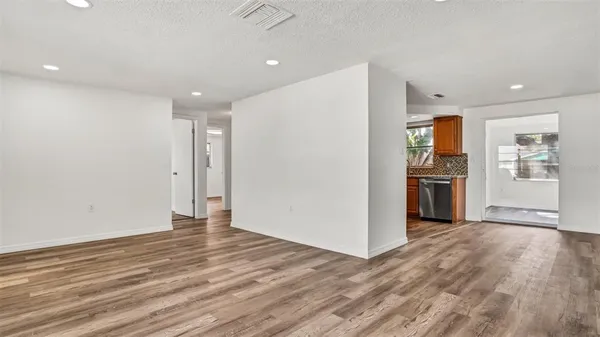 a view of a kitchen with wooden floor and a refrigerator
