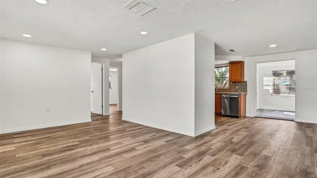 a view of a kitchen with wooden floor and a refrigerator