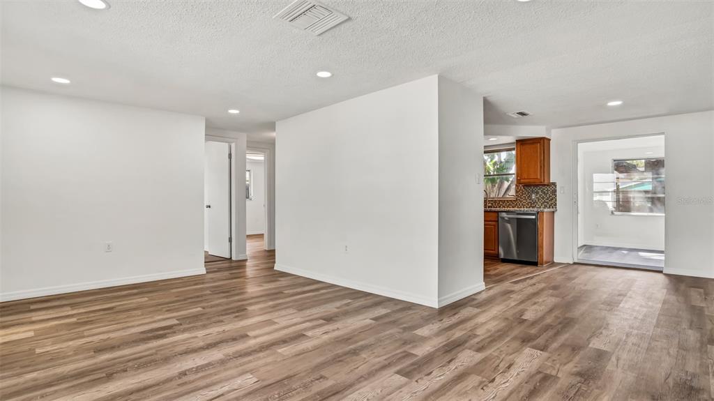7124 Parrot Drive Port Richey, FL 34668 - Photo 5 of 29 a view of a kitchen with wooden floor and a refrigerator