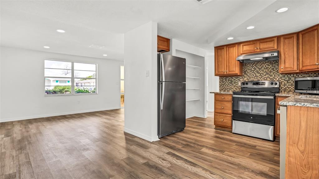7124 Parrot Drive Port Richey, FL 34668 - Photo 7 of 29 a kitchen with stainless steel appliances a refrigerator and a stove top oven