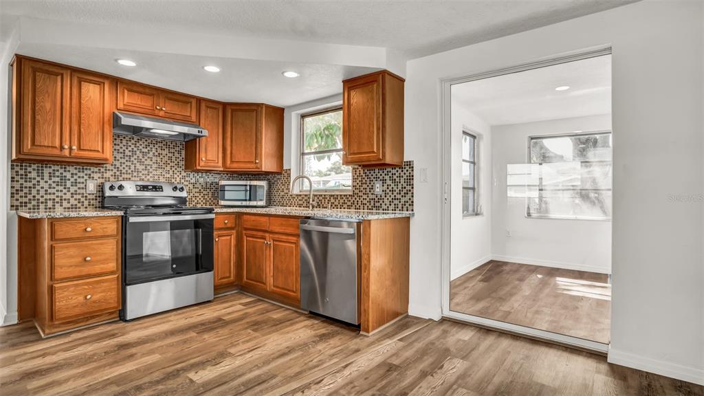 7124 Parrot Drive Port Richey, FL 34668 - Photo 8 of 29 a kitchen with stainless steel appliances granite countertop a stove a sink and a refrigerator