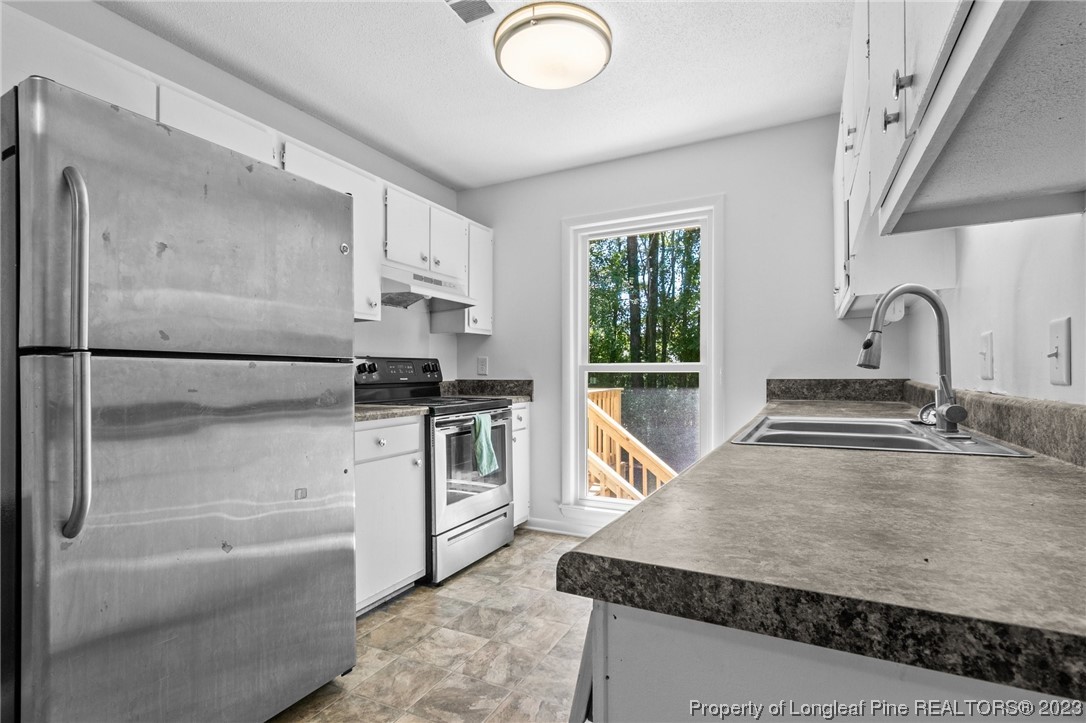 3306 Arrowhead Road Spring Lake, NC 28390 - Photo 15 of 29 a kitchen with stainless steel appliances granite countertop a sink stove and cabinets