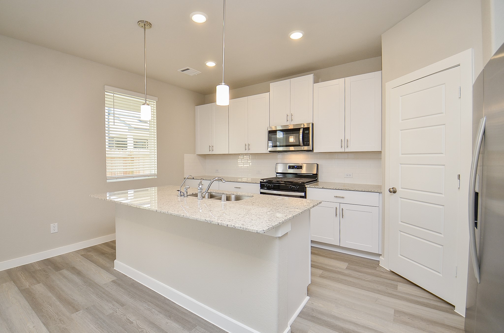 3107 Boulder Rnch Drive Houston, TX 77063 - Photo 16 of 40 a kitchen with stainless steel appliances granite countertop a sink a stove a refrigerator and white cabinets