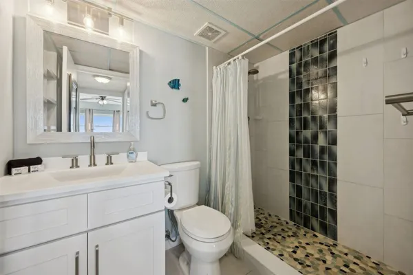 a bathroom with a sink a toilet and shower