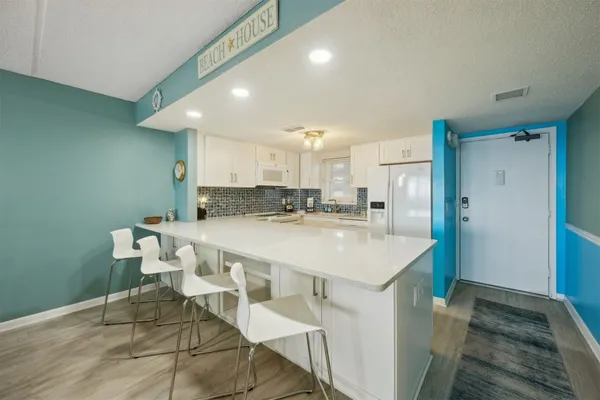 a kitchen with granite countertop white cabinets and white appliances