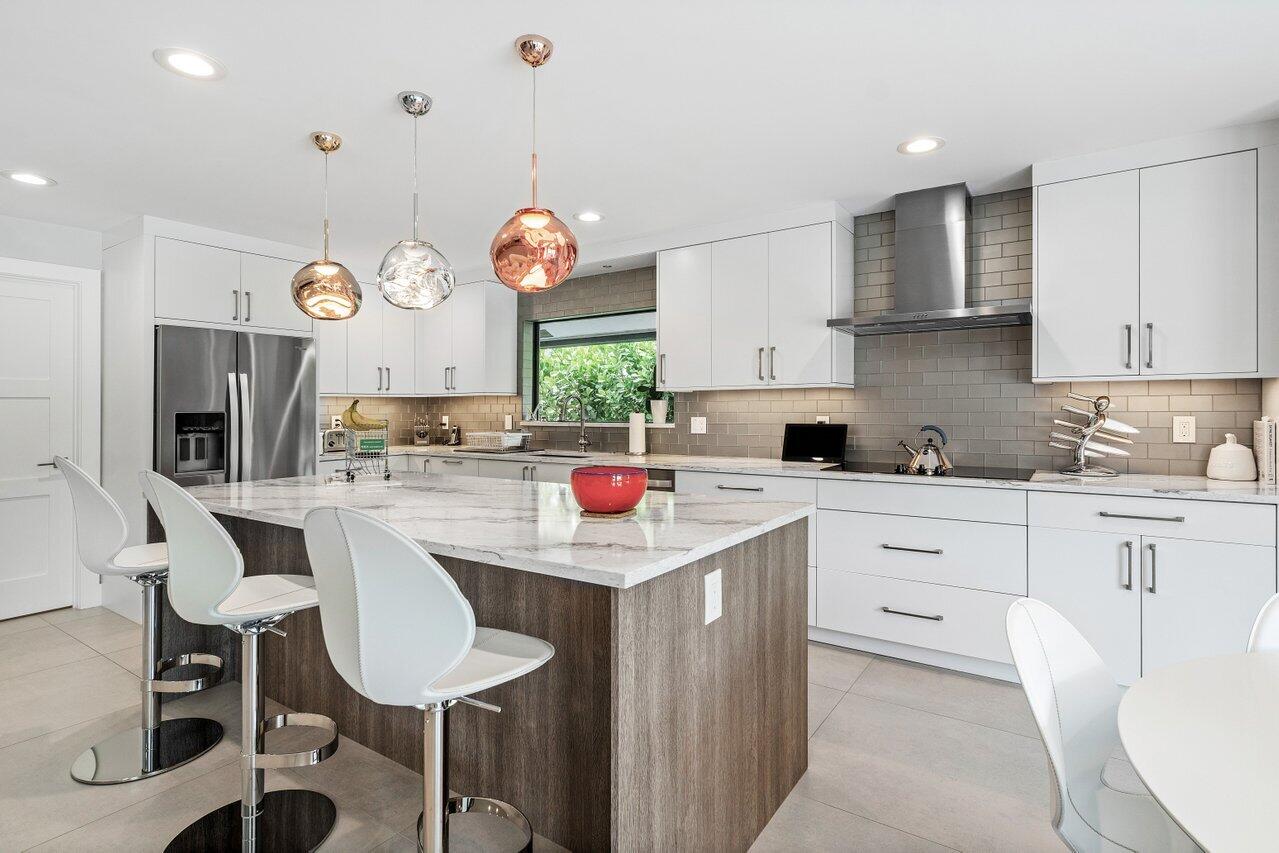 3707 Red Maple Circle Delray Beach, FL 33445 - Photo 15 of 39 a kitchen that has a lot of cabinets a island and appliances in it