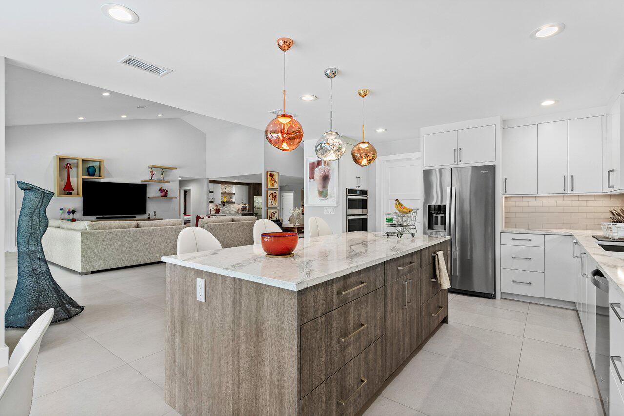 3707 Red Maple Circle Delray Beach, FL 33445 - Photo 16 of 39 a kitchen with stainless steel appliances kitchen island sink refrigerator and microwave