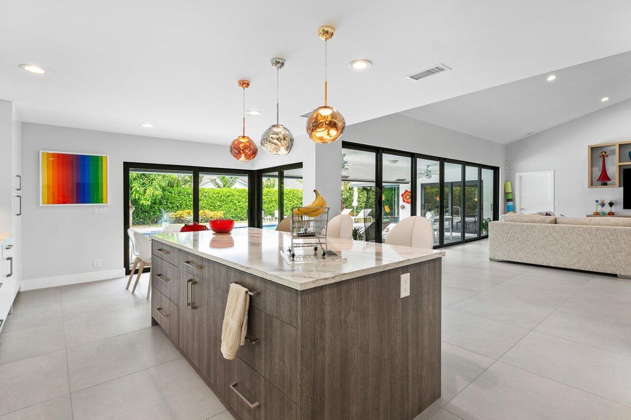 3707 Red Maple Circle Delray Beach, FL 33445 - Photo 17 of 39 a kitchen with stainless steel appliances kitchen island a large counter space and windows