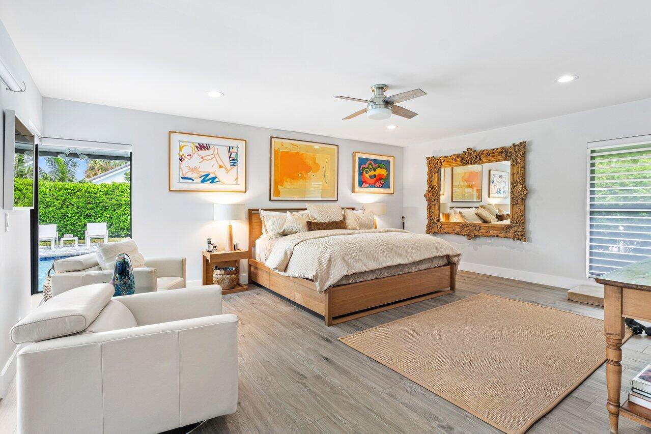 3707 Red Maple Circle Delray Beach, FL 33445 - Photo 20 of 39 a bedroom with a large bed a couch and paintings on the wall